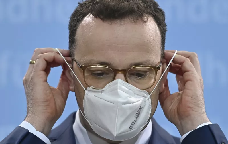 German Health Minister Jens Spahn puts his face mask back on after addressing a press conference at the Health Ministry in Berlin on March 15, 2021 as it was announced that Germany had halted the use of the AstraZeneca's coronavirus (Covid-19) vaccine. - Germany on March 15 halted the use of AstraZeneca's coronavirus vaccine after reported blood clotting incidents in Europe,  saying that a closer look was necessary. (Photo by John MACDOUGALL / AFP)