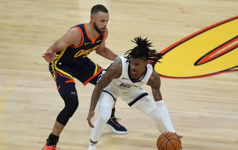 Memphis Grizzlies' Ja Morant, right, drives against Golden State Warriors' Stephen Curry during the first half of an NBA basketball Western Conference play-in game in San Francisco, Friday, May 21, 2021. (AP Photo/Jed Jacobsohn)