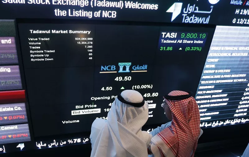 (FILES) In this file photo taken on November 12, 2014, Saudi investors monitor stocks at the exchange market department at the National Commercial  Bank (NCB) in Riyadh. - Saudi shares dropped three percent at the start of trading on September 15, 2019, the first session after drone attacks on two major oil facilities knocked out more than half the kingdom's production. (Photo by Fayez Nureldine / AFP)