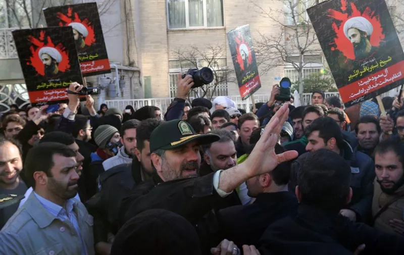 Tehran's police chief Hossein Sajedinia (C) asks protesters to end their rally against the execution of prominent Shiite Muslim cleric Nimr al-Nimr by Saudi authorities, and leave the area outside the Saudi embassy on January 3, 2016, in Tehran. Iran and Iraq's top Shiite leaders condemned Saudi Arabia's execution of Nimr, warning ahead of protests that the killing was an injustice that could have serious consequences. AFP PHOTO / ATTA KENARE / AFP / ATTA KENARE