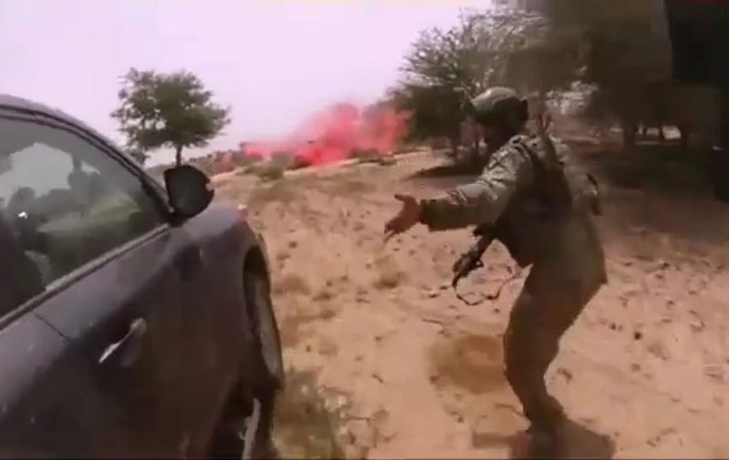 This video screen grab obtained March 5, 2018 courtesy of Nashir News Agency (ISIS affiliated propaganda media),shows purportedly the October 4, 2017, ambush of American and Nigerien soldiers in Tongo Tongo, Niger. - A propaganda video released by the Islamic State group showing the deadly ambush of US troops in Niger raised fresh questions Monday as to the nature of the mission and why the soldiers had been left so vulnerable. The distressing video, distributed by a pro-IS news agency, includes graphic footage taken by a solder wearing a helmet camera. It shows the chaos of the attack, including the solider wearing the camera being shot dead, with apparent IS fighters stalking past his body.The Defense Department "is aware of alleged photos and IS propaganda video from the October 4, 2017 terrorist attack in Niger. The release of these materials demonstrates the depravity of the enemy we are fighting," the Pentagon said in a statement.The nine-minute video, set to Islamic chanting, includes an image of IS leader Abu Bakr al-Baghdadi and footage of pick-up trucks rolling through a desert landscape. (Photo by Handout / Nashir News Agency / AFP) / RESTRICTED TO EDITORIAL USE - MANDATORY CREDIT "AFP PHOTO / NASHIR NEWS AGENCY/HANDOUT" - NO MARKETING NO ADVERTISING CAMPAIGNS - DISTRIBUTED AS A SERVICE TO CLIENTS