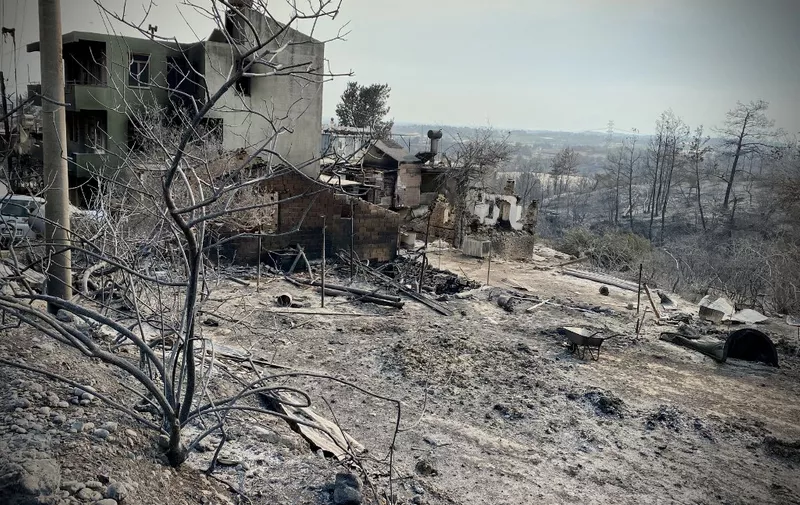This photograph taken on July 31, 2021 near the town of Manavgat shows burnt houses as a massive forest fire which engulfed a Mediterranean resort region on Turkey's southern coast. - At least three people were reported dead on July 29, 2021 and more than 100 injured as firefighters battled blazes engulfing a Mediterranean resort region on Turkey's southern coast. Officials also launched an investigation into suspicions that the fires that broke out July 28 in four locations to the east of the tourist hotspot Antalya were the result of arson. (Photo by - / AFP)