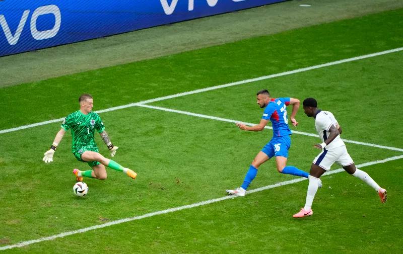 Slovakia's Ivan Schranz, centre, scores the opening goal past England's goalkeeper Jordan Pickford during a round of sixteen match between England and Slovakia at the Euro 2024 soccer tournament in Gelsenkirchen, Germany, Sunday, June 30, 2024. (AP Photo/Ebrahim Noroozi)