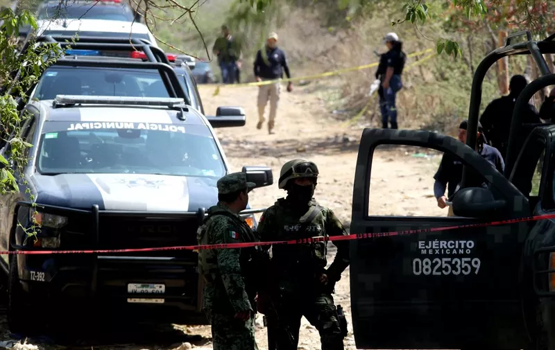 Members of the Mexican Army work at the site of an explosive attack against a police patrol in Tlajomulco de Zuñiga, a suburb at the city of Guadalajara, Jalisco State, Mexico on July 12, 2023. An explosives attack on a police patrol left six people dead and a dozen wounded in one of the regions of Mexico worst hit by drug cartel-related violence, authorities said Wednesday. (Photo by ULISES RUIZ / AFP)