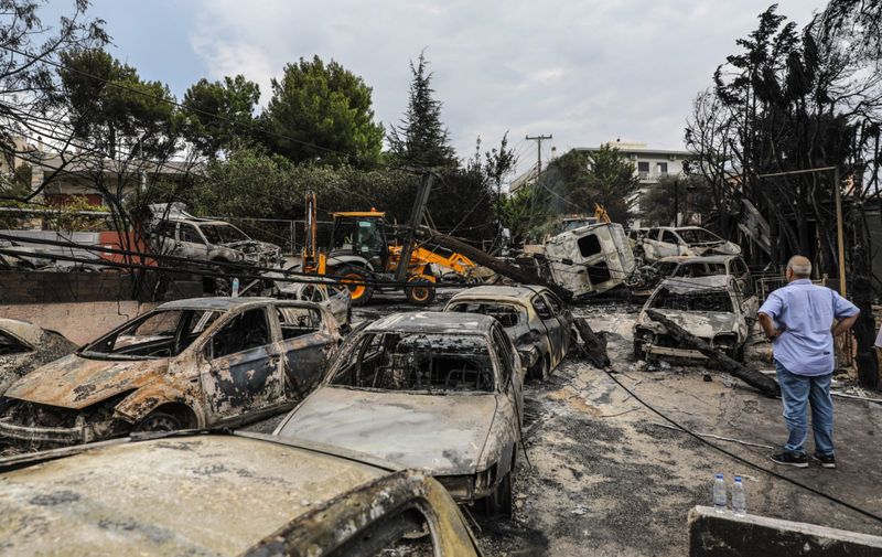 (180724) -- MATI (GREECE), July 24, 2018 () -- A man looks at burned vehicles in Mati, a seaside town east of Athens, Greece, on July 24, 2018. The number of killed in the devastating fires near Athens was revised upward to 74 on Tuesday afternoon, while the search for more victims continued in Attica's eastern coast, Greek national news agency AMNA reported., Image: 379367757, License: Rights-managed, Restrictions: WORLD RIGHTS excluding China- Fee Payable Upon Reproduction - For queries contact Avalon.red - sales@avalon.red  London: +44 (0) 20 7421 6000  Los Angeles: +1 (310) 822 0419  Berlin: +49 (0) 30 76 212 251, Model Release: no, Credit line: Profimedia, UPPA News