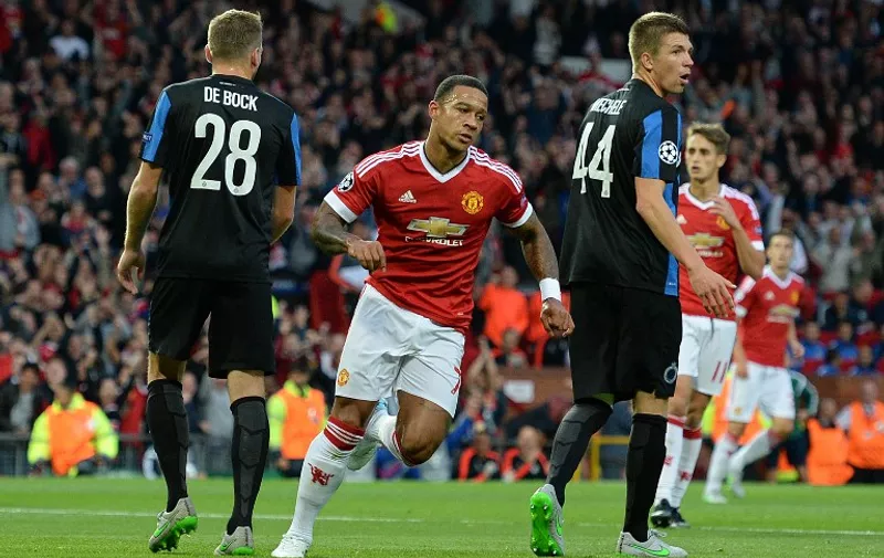 Manchester United's Dutch midfielder Memphis Depay (2nd L) wheels away in celebration after scoring his team's first goal during the UEFA Champions League play off football match between Manchester United and Club Brugge at Old Trafford in Manchester, north west England, on August 18, 2015. AFP PHOTO / OLI SCARFF