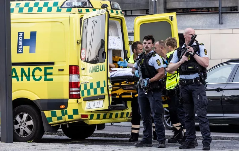 Police stand guard near an ambulance in front of the Fields shopping mall, where a gunman killed three people and wounded several others in Copenhagen on July 3, 2022. - A 22-year-old Danish man was arrested after the shooting but his motives were unclear, police said. (Photo by Olafur STEINAR GESTSSON / Ritzau Scanpix / AFP) / Denmark OUT