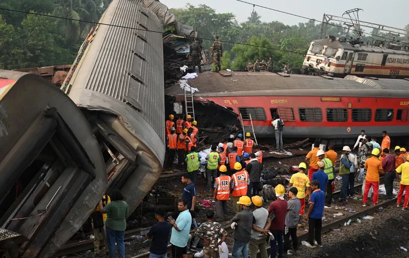 Rescue workers gather around damaged carriages at the accident site of a three-train collision near Balasore, about 200 km (125 miles) from the state capital Bhubaneswar in the eastern state of Odisha, on June 3, 2023. At least 288 people were killed and more than 850 injured in a horrific three-train collision in India, officials said on June 3, the country's deadliest rail accident in more than 20 years. (Photo by DIBYANGSHU SARKAR / AFP)