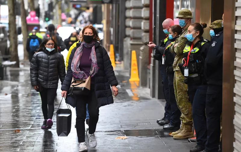 Police and defence personnel stand guard outside a Covid isolation hotel in Melbourne on June 18, 2021 as people return to the city centre after an easing of restrictions on travel and mask wearing. (Photo by William WEST / AFP)