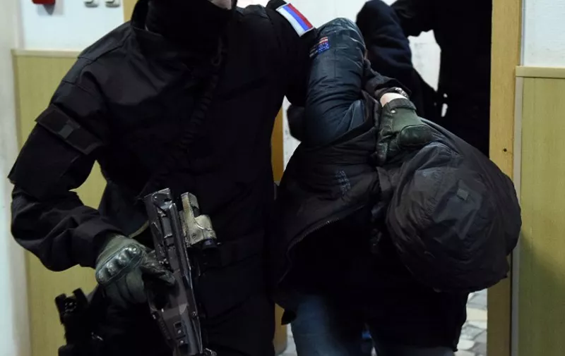 An unidentified suspect (R) detained over the killing of Russian opposition activist Boris Nemtsov is escorted by a policeman in a court corridor in Moscow on March 8, 2015. Five suspects accused of involvement in the killing of Nemtsov appeared in court to determine whether they will be officially placed in detention. Two Chechens, Zaur Dadayev and Anzor Gubashev were officially accused of "the murder of Boris Nemtsov and three others are still suspects," Anna Fadeyeva, spokeswoman for the court in central Moscow told the RIA Novosti news agency. AFP PHOTO / DMITRY SEREBRYAKOV