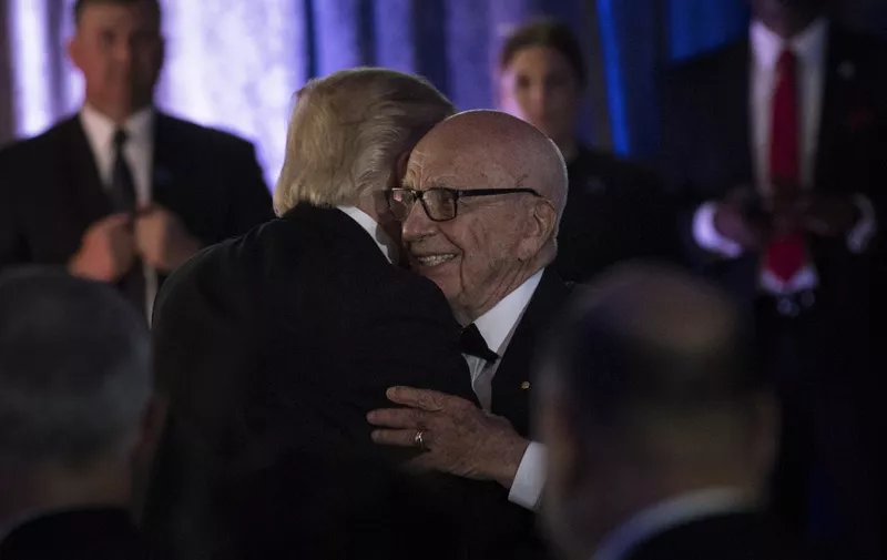 US President Donald Trump (L) is embraced by Rupert Murdoch, Executive Chairman of News Corp, during a dinner to commemorate the 75th anniversary of the Battle of the Coral Sea during WWII onboard the Intrepid Sea, Air and Space Museum May 4, 2017 in New York, New York. (Photo by Brendan Smialowski / AFP)