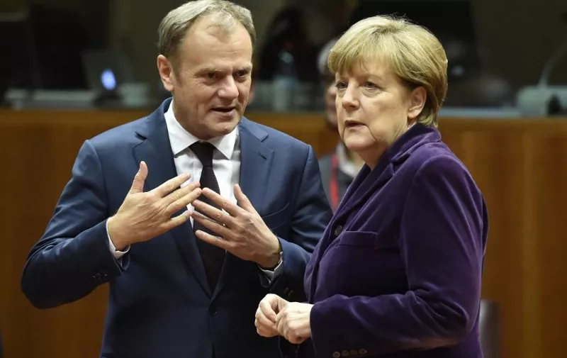 European Council president Donald Tusk (L) speaks with German Chancellor Angela Merkel before the final European Union (EU) summit of the year at the European Council in Brussels on December 17, 2015. 
EU leaders will discuss British Prime Minister David Cameron's controversial reform demands as well as plans for a new European border force to deal with the migration crisis. / AFP / ALAIN JOCARD