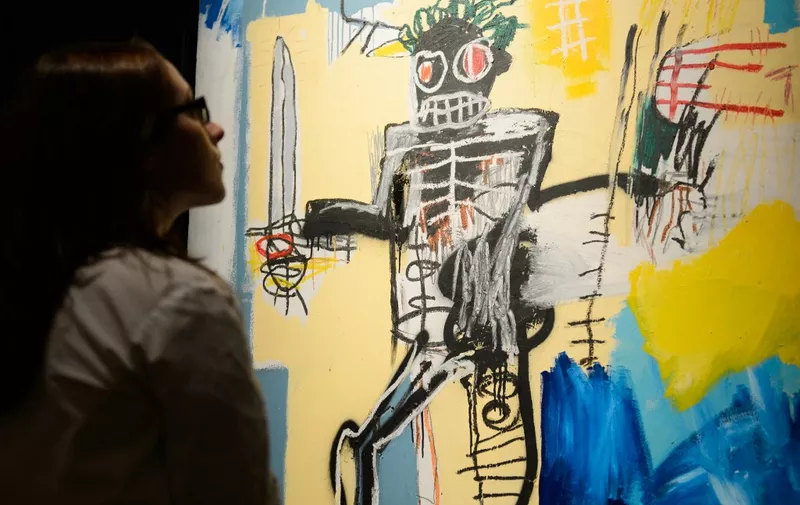 A gallery assistant poses with US artist Jean-Michel Basquiat's "Warrior" at Sotheby's auction house in central London on June 14, 2012.  The piece has an estimated value of 500,000 - 700,000 GBP (777,000 - 1 million USD)  and is due to be sold at it's forthcoming sale of Impressionist &amp; Modern Art and Contemporary Art sale on June 19, 2012. AFP PHOTO / LEON NEAL (Photo by LEON NEAL / AFP)