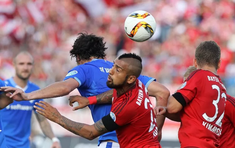 Bayern Munich's Chilean midfielder Arturo Vidal (C) and Darmstadt's midfielder Tobias Kempe (L) vie for the ball during the German first division Bundesliga football match SV Darmstadt 98 vs FC Bayern Munich, in Darmstadt, southern Germany on September 19, 2015.  AFP PHOTO / DANIEL ROLAND

RESTRICTIONS: DURING MATCH TIME: DFL RULES TO LIMIT THE ONLINE USAGE TO 15 PICTURES PER MATCH AND FORBID IMAGE SEQUENCES TO SIMULATE VIDEO. 
== RESTRICTED TO EDITORIAL USE ==  FOR FURTHER QUERIES PLEASE CONTACT DFL DIRECTLY AT + 49 69 650050.
