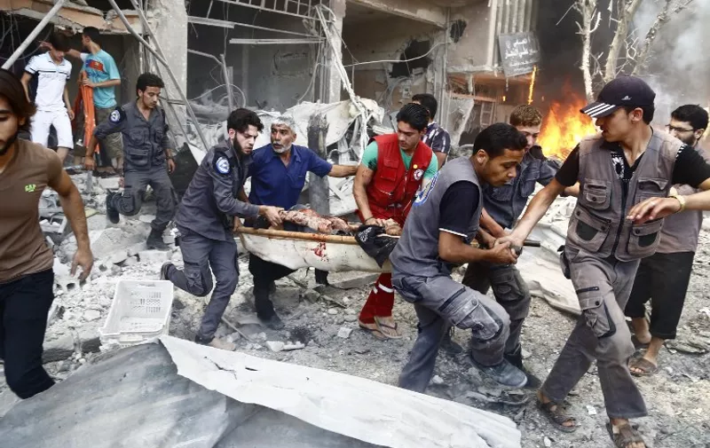 TOPSHOTS
Emergency services and civilians carry a serverely wounded man on a stretcher following an air strike on Douma, a rebel-held suburb east of the Syrian capital Damascus, on July 27, 2015. AFP PHOTO / SAMEER AL-DOUMY