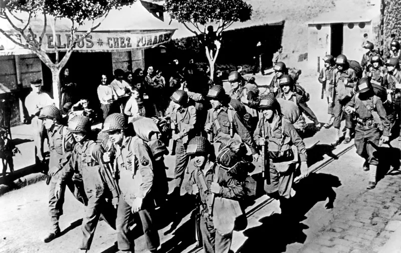 US Army soldiers march 11 November 1942 through a section of Oran, French Algeria, after the greatest armada of ships and aircraft ever assembled for a single operation landed 07 November American troops in Vichy-French North-Africa. The surprise operation, which brought 140,000 American troops from the US marked the beginning of a great Allied offensive against the Axis forces. AFP PHOTO (Photo by AFP)