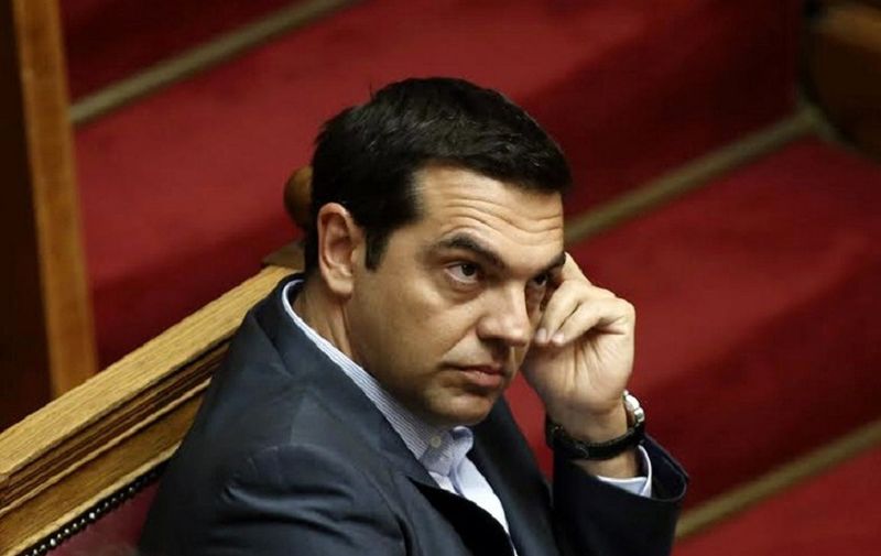 Greek Prime Minister Alexis Tsipras  attends an overnight parliamentary debate in Athens on August 14, 2015. A majority of Greek lawmakers on August 14 approved the country's third international bailout after an all-night debate, an AFP count showed. Prime Minister Alexis Tsipras had earlier urged the chamber to approve the deal "to assure the country's ability to survive and keep on fighting." AFP PHOTO/ PANAYIOTIS TZAMAROS