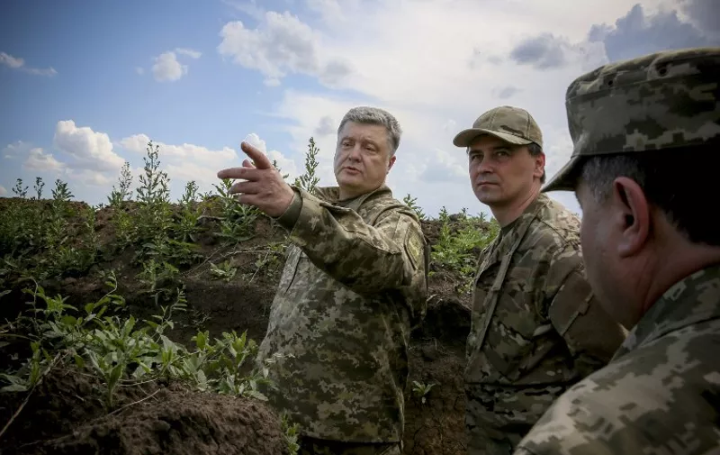 An hand out picture taken and released by Ukrainian presidential press service on June 11, 2015 shows the Ukrainian President Petro Poroshenko (L) speaking with soldiers as he examines fortifications of Ukrainian forces during his visit to Mariupol district, in Donetsk region.  Washington's UN envoy accuses Russia today of spinning "outright lies" on Ukraine designed to hide the Kremlin's direct involvement in a war it launched to thwart Kiev's alliance with the West.
 AFP PHOTO/ HAND OUT / UKRAINIAN PRESIDENTIAL PRESS SERVICE/ MIKHAIL PALINCHAK
= RESTRICTED TO EDITORIAL USE - MANDATORY CREDIT "AFP PHOTO / PRESIDENTIAL PRESS SERVICE / MIKHAIL PALINCHAK" - NO MARKETING NO ADVERTISING CAMPAIGNS - DISTRIBUTED AS A SERVICE TO CLIENTS =