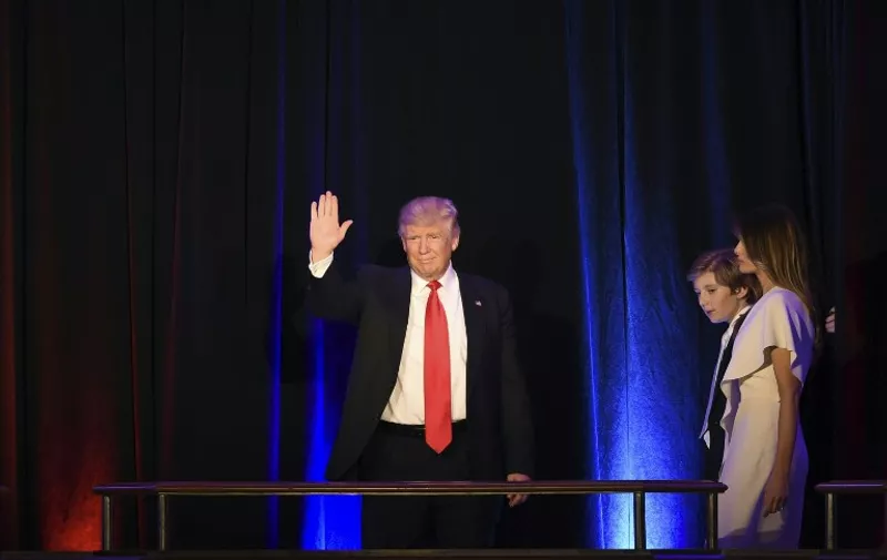 Republican presidential candidate Donald Trump waves from the balcony flanked by members of his family shortly before speaking to supporters during election night at the New York Hilton Midtown in New York on November 9, 2016. 
Trump won the US presidency. / AFP PHOTO / Timothy A. CLARY