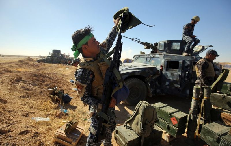 An Iraqi policeman inspects his weapon at the Qayyarah military base, about 60 kilometres (35 miles) south of Mosul, on October 16, 2016, as they prepare for an offensive to retake Mosul, the last IS-held city in the country, after regaining much of the territory the jihadists seized in 2014 and 2015. / AFP PHOTO / AHMAD AL-RUBAYE