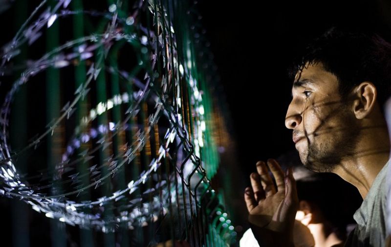 A refugee looks over the shut off border of Hungary near to Horgos in Serbia, 15 Septemeber 2015. The Hungraian immigration departments closed the border to all traffic on September 15 2015. Photo: Gregor Fischer/dpa