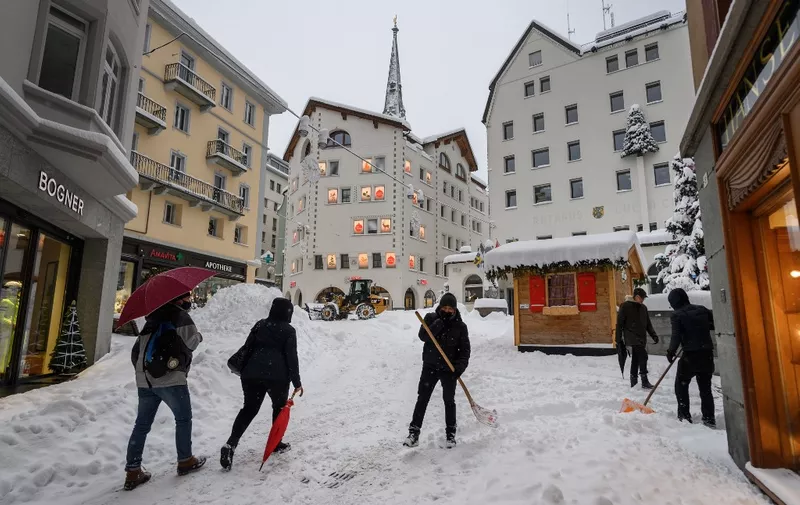 Workers clean the streets after heavy snow falls hit the Swiss ski resort of St. Moritz on December 5, 2020 and forced to cancel the Women's Super G race of the FIS Alpine Ski World Cup. (Photo by Fabrice COFFRINI / AFP)