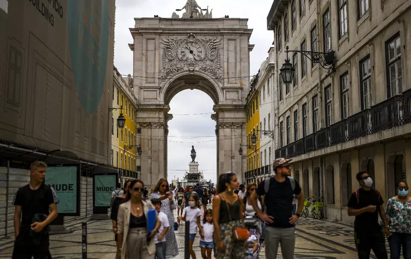 Tourists walk pass the Augusta street arch in Lisbon on August 11, 2020 ahead of the UEFA Champions League finals. (Photo by PATRICIA DE MELO MOREIRA / AFP)