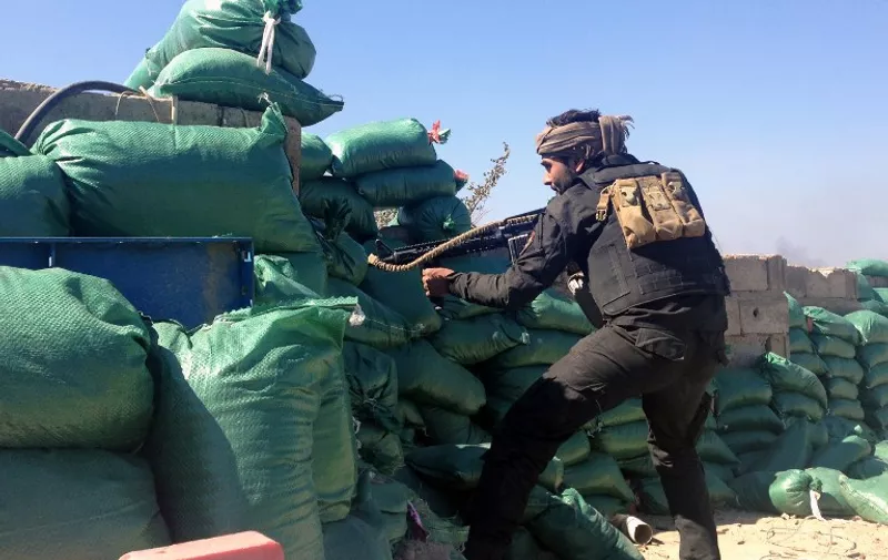 A member of the tribal groups fighting along with the Iraqi government security forces takes a position behind sandbags during clashes with jihadists in the Hosh district of Ramadi as the Islamic State jihadist group launched a coordinated attack on government-held areas of the western Iraqi city on March 11, 2015, involving seven almost simultaneous suicide car bombs, police said. At least 10 people were killed and 30 wounded in the attack, according to initial reports by police and hospital sources in the city, capital of Anbar province.   AFP PHOTO / AZHAR SHALLAL