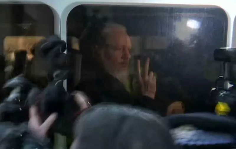 A video grab taken from AFP TV footage shows WikiLeaks founder Julian Assange as he is driven by British Police to Westminster Magistrates Court in London on April 11, 2019. - WikiLeaks founder Assange appeared in a London courtroom on Thursday, hours after being arrested in Ecuador's embassy on an extradition request from the United States and for breaching bail in Britain. (Photo by - / AFP)
