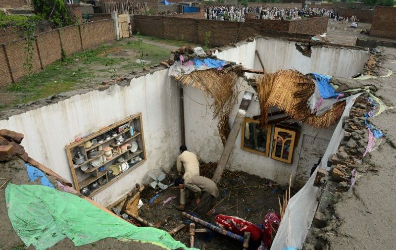 TOPSHOTS
Pakistani residents collect belongings at their home after it was damaged in heavy rain and winds in Peshawar on April 27, 2015. A severe storm in northwest Pakistan, dubbed a "mini-cyclone", has killed 44 people and injured more than 200, officials said, raising their previous death toll. AFP PHOTO/ A MAJEED