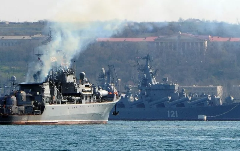 (FILES) In this file photo taken on March 30, 2014 the Russian navy patrol ship 'Pytliviy' (L) navigates near the Russian Navy flagship missile cruiser 'Moskva' (R) docked in the bay of the Crimean city of Sevastopol. - The Moskva, a Russian warship in the Black Sea, was "seriously damaged" by an ammunition explosion, Russian state media said on April 14, 2022. (Photo by AFP)