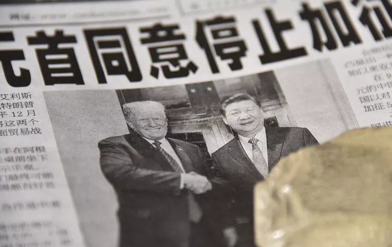 A newspaper featuring a front page story about the meeting between US President Donald Trump and Chinese President Xi Jinping as seen at a news stand in Beijing on December 3, 2018. - The headline says the two leaders agreed not to increase tarrifs. China's state-run media hailed the trade war truce with the United States as "momentous" on December 3 but warned of complex negotiations ahead, even as President Donald Trump said Beijing agreed to cut car tariffs. (Photo by GREG BAKER / AFP)