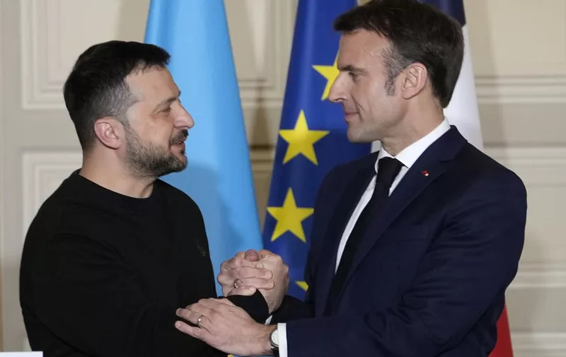 EDITORS NOTE: Graphic content / France's President Emmanuel Macron (R) shakes hands with Ukraine's President Volodymyr Zelensky (L) during a press conference at the presidential Elysee palace in Paris on February 16, 2024, after signing a bilateral security agreement. French President Emmanuel Macron and Ukraine's Volodymyr Zelensky on February 16, 2024 signed a security pact calling for French military and civilian aid for Kyiv in its war against Russia, including a French aid pledge for up to three billion euros ($3.2 billion) for 2024, after 1.7 billion in 2022 and 2.1 billion last year. (Photo by Thibault Camus / POOL / AFP)