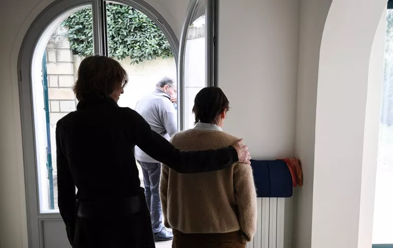 A carer helps an elderly resident - one of three alzheimer sufferers in the establishment- in a house at L'Hay-les- Roses on the outskirts of Paris on February 17, 2022, which is run as an alternative to the traditional carehome model. (Photo by ALAIN JOCARD / AFP)