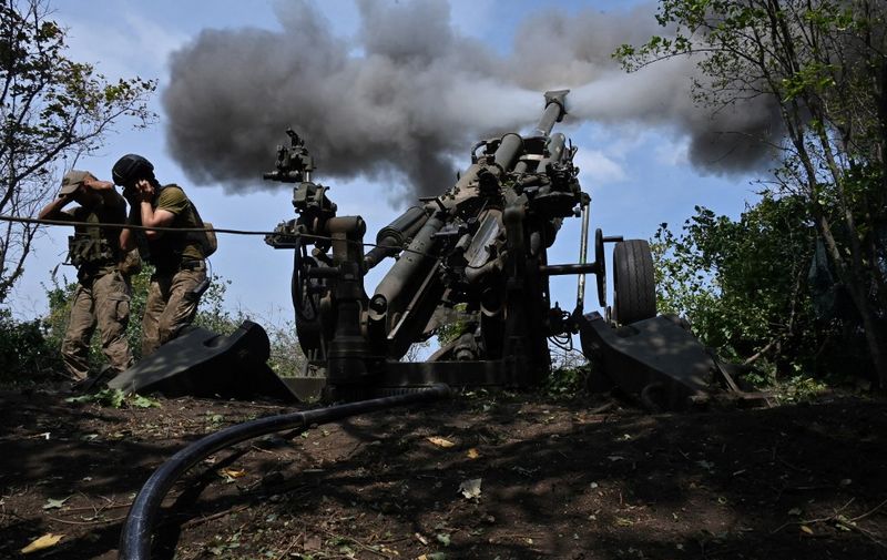 Ukrainian gunmen fire a US made M777 howitzer from their position on the front line in Kharkiv region on August 1, 2022, amid Russia's military invasion launched on Ukraine. (Photo by SERGEY BOBOK / AFP)