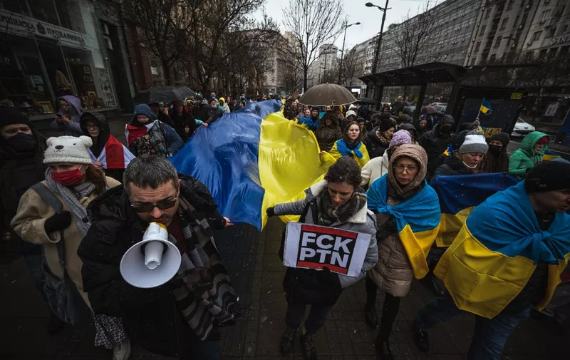 Protestors carry a giant Ukrainian flag during a demonstration against Russia's military invasion on Ukraine, in Belgrade, on March 6, 2022, 11 days after Russia launched a military invasion on Ukraine. (Photo by Andrej ISAKOVIC / AFP)