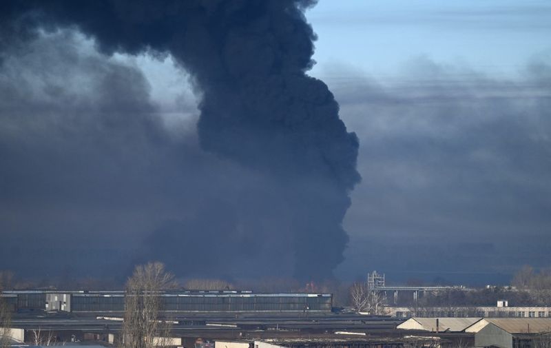 Black smoke rises from a military airport in Chuguyev near Kharkiv  on February 24, 2022. - Russian President Vladimir Putin announced a military operation in Ukraine today with explosions heard soon after across the country and its foreign minister warning a "full-scale invasion" was underway. (Photo by ARIS MESSINIS / AFP)