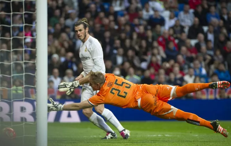 Real Madrid's Welsh forward Gareth Bale scores past Rayo Vallecano's goalkeeper Yoel during the Spanish league football match Real Madrid CF vs Rayo Vallecano de Madrid at the Santiago Bernabeu stadium in Madrid on December 20, 2015. AFP PHOTO / CURTO DE LA TORRE / AFP / CURTO DE LA TORRE