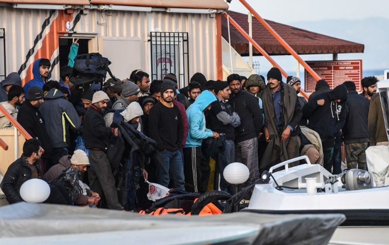 Captured Afghani migrants disembark from a Turkish coast guard boat in the morning on April 4, 2016 in the port of Dikili district in Izmir, after trying to cross to Greek island Lesbos. 
Greece sent a first wave of migrants back to Turkey on April 4 under an EU deal that has faced heavy criticism from rights groups. Under the agreement, designed to halt the main influx which comes from Turkey, all "irregular migrants" arriving since March 20 face being sent back, although the deal calls for each case to be examined individually. For every Syrian refugee returned, another Syrian refugee will be resettled from Turkey to the EU, with numbers capped at 72,000.
 / AFP PHOTO / OZAN KOSE