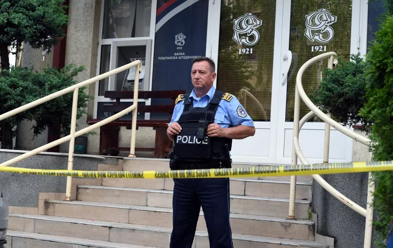 A Kosovar police officer guards an office of the Postal Savings Bank from Serbia, in Mitrovica, on May 20, 2024. Since February 1, 2024, transactions in Serbian Dinars that Pristina tolerated in areas populated by ethnic Serbs, were banned and the euro was imposed as the only legal currency, making it difficult for Kosovo Serbs to receive salaries or aid from the Serbian state. Kosovar police said they closed six branches of the Serbian-licenced Postal Savings Bank because they were operating "illegally". (Photo by AFP)