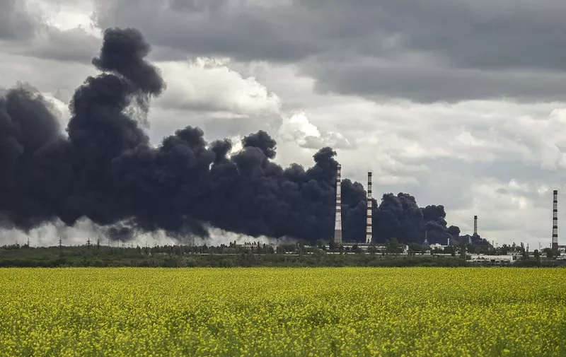 Smoke rises from an oil refinery after an attack outside the city of Lysychansk in the eastern Ukranian region of Donbas, on May 22, 2022, on the 88th day of the Russian invasion of Ukraine. (Photo by ARIS MESSINIS / AFP)