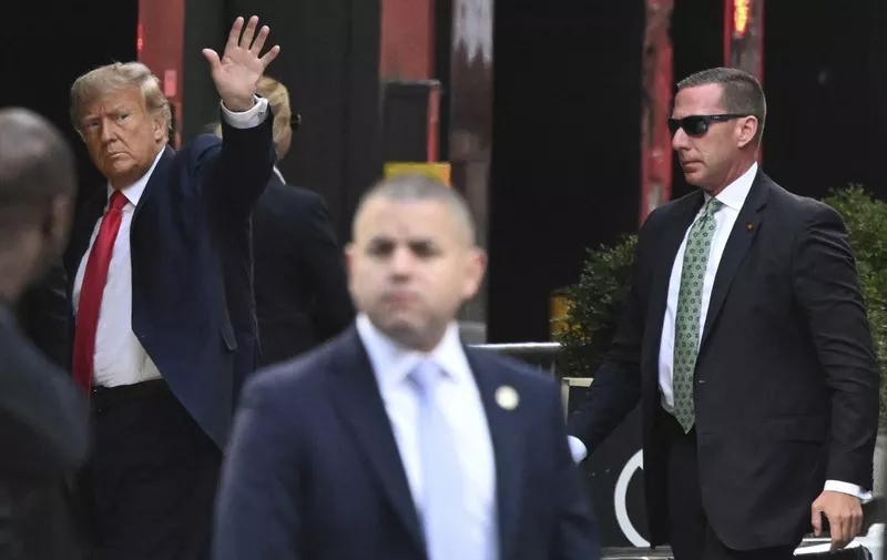 Former US President Donald Trump (L) waves as he arrives at Trump Tower in New York on April 3, 2023. - Trump arrived on April 3, 2023 in New York where he will surrender to unprecedented criminal charges, taking America into uncharted and potentially volatile territory as he seeks to regain the presidency. The 76-year-old Republican, the first US president ever to be criminally indicted, will be formally charged Tuesday over hush money paid to a porn star during the 2016 election campaign. (Photo by Ed JONES / AFP) / ALTERNATE CROP