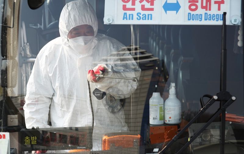 A worker from a disinfection service sprays disinfectant in a bus departing to Daegu as part of preventive measures against the spread of the COVID-19 coronavirus, at a bus terminal in Ansan, south of Seoul, on February 20, 2020. - South Korea's coronavirus numbers nearly doubled February 20 -- almost half of them in a cluster centred on a sect in the city of Daegu -- and the country saw its first death of an infected patient. (Photo by - / YONHAP / AFP) / - South Korea OUT / REPUBLIC OF KOREA OUT  NO ARCHIVES  RESTRICTED TO SUBSCRIPTION USE