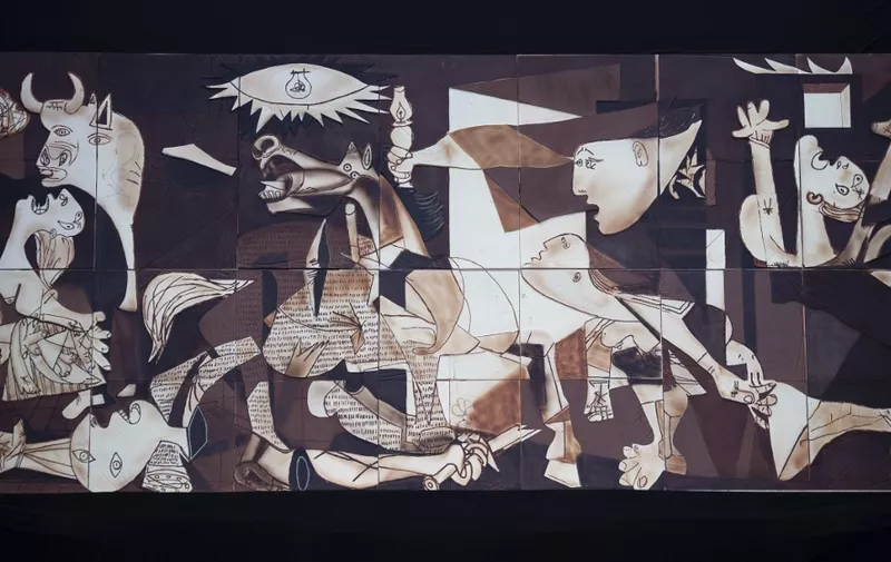 A life-size chocolate version of Picasso's painting "Guernica" made by members of Euskal Gozogileak (Basque Confectioners) association is pictured during its public presentation in the Spanish Basque town of Gernika on April 25, 2021. - The 7.70 x 3.50 meter chocolate replica of "Guernica" made by around 40 confectioners is exhibited in the town of Gernika to commemorate the 85th anniversary of the bombing raid of the small Basque town by Nazi aircraft, at the behest of General Francisco Franco in 1937. (Photo by ANDER GILLENEA / AFP)