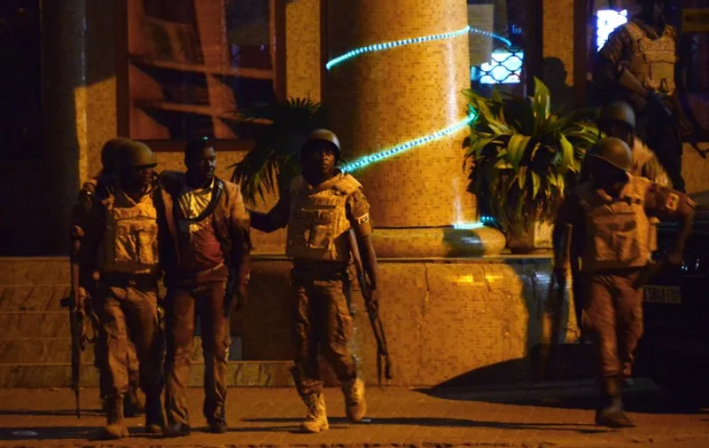 Burkina Faso's soldiers evacuate an injured man (3rd L) from the Splendid hotel during an attack on both the hotel and a restaurant by Al-Qaeda linked gunmen late on January 15, 2016. 
Burkina Faso troops supported by French special forces were battling Al-Qaeda linked gunmen in the early hours of January 16 in a Ouagadougou hotel where at least 20 people have been killed. / AFP / AHMED OUOBA