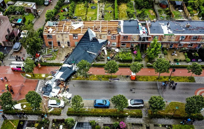 An aerial view shows the damage to the roof of adjacent buildings after a tornado ripped through the southwestern seaside city of Zierikzee on June 27, 2022. - A tornado ripped through the city of Zierikzee, killing at least one person and injuring 10 others in the first fatal twister to hit the country for three decades. (Photo by Jeffrey GROENEWEG / ANP / AFP) / Netherlands OUT