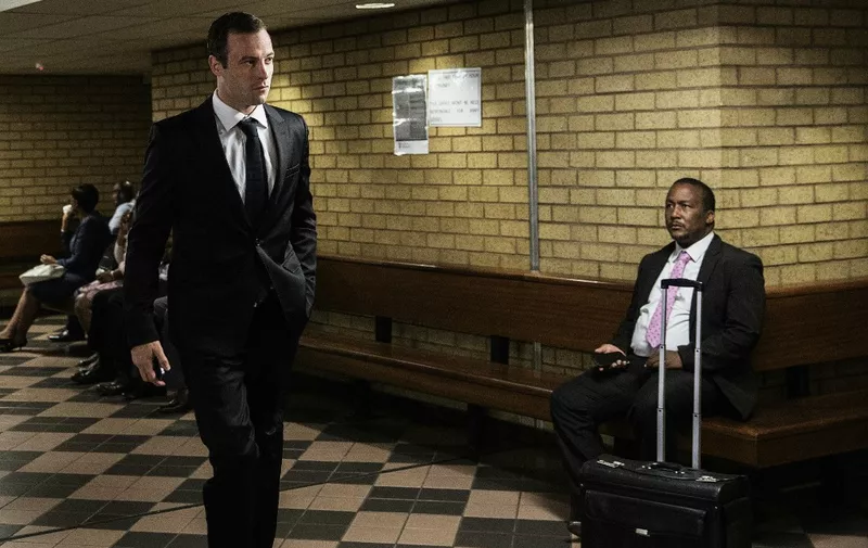 (FILES) South African Paralympian Oscar Pistorius (L) arrives at Pretoria High Court for today's postponement hearing in his murder case on April 18, 2016 in Pretoria, South Africa. South African Paralympic champion Oscar Pistorius was granted early release from prison on parole on Friday, a decade after he killed his girlfriend, in a crime that gripped the world, prison authorities said. (Photo by GIANLUIGI GUERCIA / AFP)