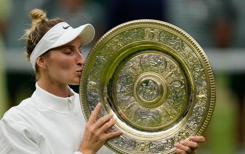 Czech Republic's Marketa Vondrousova celebrates with the trophy after beating Tunisia's Ons Jabeur in the women's singles final on day thirteen of the Wimbledon tennis championships in London, Saturday, July 15, 2023. (AP Photo/Alastair Grant)