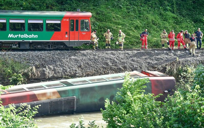 Emergency personnel work close to a railway car that has fallen into the river Mur at the accident site of a derailed train of the Murtalbahn railways in Ramingstein in the Salzburg Lungau region, Austria, on July 9, 2021. (Photo by FRANZ NEUMAYR / APA / AFP) / Austria OUT