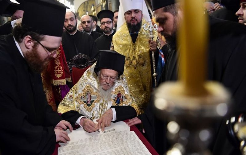 Ecumenical Patriarch Bartholomew I (C), flanked by Metropolitan Epiphanius, the head of the independent Ukrainian Orthodox Church (C-R), signs the "Tomos" decree of autocephaly to Ukrainian church at the Patriarchal Church of St. George on January 5, 2019 in Istanbul. - The creation of an Orthodox church in Ukraine independent of Moscow ends more than 300 years of Moscow domination. (Photo by OZAN KOSE / AFP)
